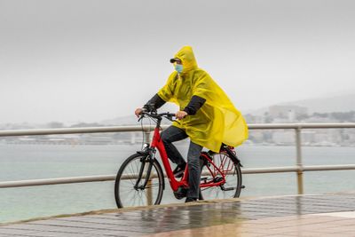 Man riding bicycle in sea against sky