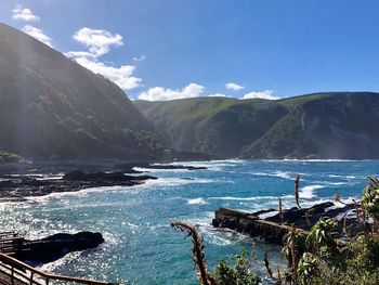 Scenic view of sea and mountains against sky