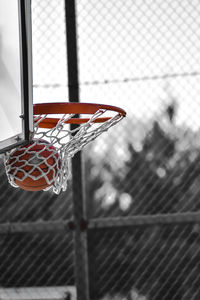 Close-up of basketball hoop against fence