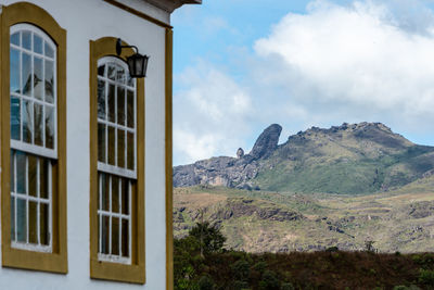 Built structure by mountain against sky