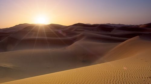 Scenic view of desert against sky during sunset