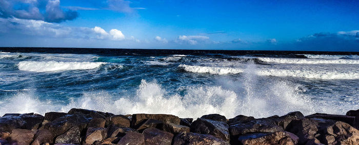 Panoramic view of sea against blue sky