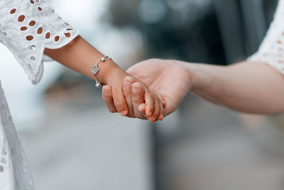 Midsection of couple holding hands