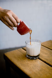 Cropped hand of woman holding coffee on table