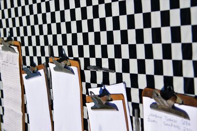 Close-up of papers and clipboards hanging against wall