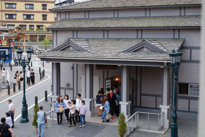 People walking on street amidst buildings in city