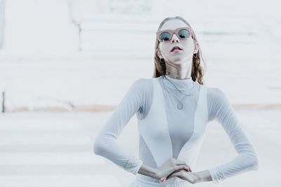 Portrait of young woman wearing sunglasses standing outdoors