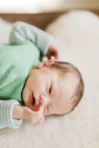 High angle view of baby boy lying on bed at home