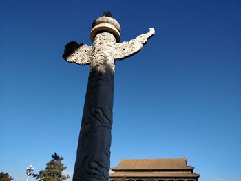 Low angle view of statue against clear blue sky