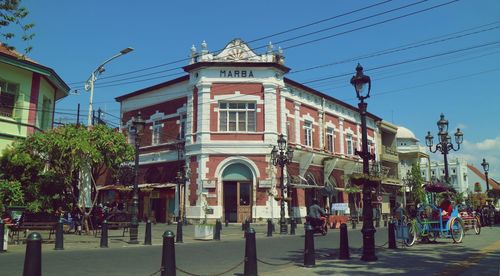 People walking on street against buildings in city