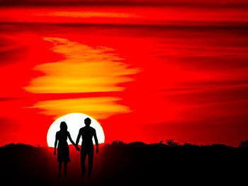 Silhouette couple walking against red sky during sunset