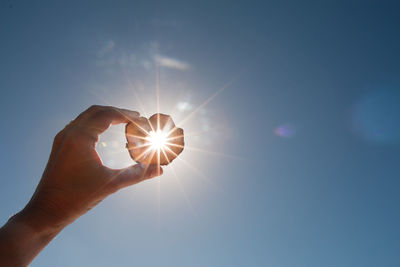 Sunlight streaming through hand against bright sun