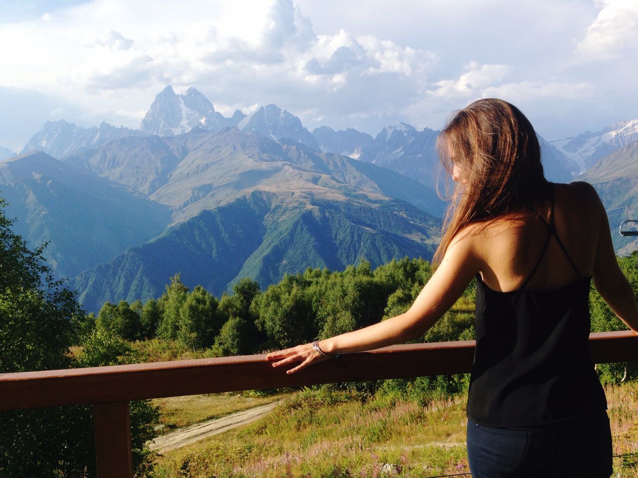 mountain, lifestyles, young adult, mountain range, leisure activity, casual clothing, sky, young women, tranquility, landscape, scenics, tranquil scene, person, tree, looking at view, standing, three quarter length, beauty in nature