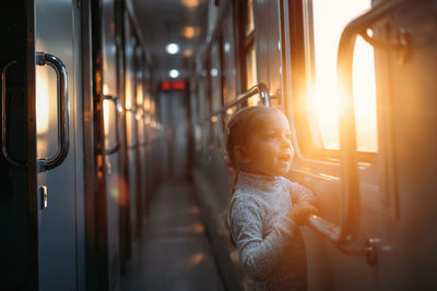 Rear view of woman standing in train