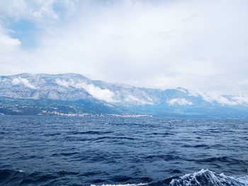 Scenic view of sea and mountains against sky