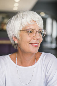 Close-up of smiling woman looking away in cafe