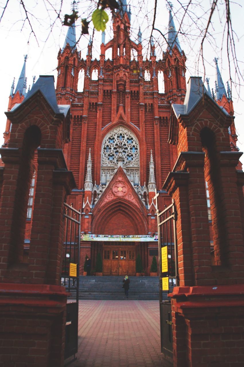 architecture, built structure, place of worship, religion, building exterior, spirituality, in a row, temple - building, walkway, the way forward, long, church, facade, cloud, pathway, arch, outdoors, sky, multi colored, narrow, creativity, archway