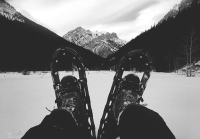 Low section of person wearing snowshoes during winter