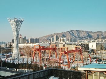 Bridge by buildings against clear blue sky