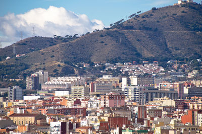 Aerial view of buildings in city against sky