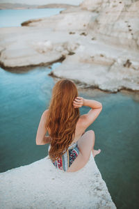 Woman sitting on rock at beach