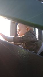 Close-up portrait of smiling boy on window