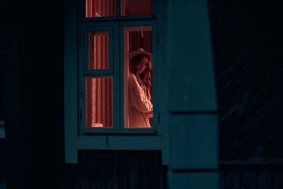 Woman standing against window