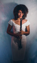 Portrait of young woman playing guitar