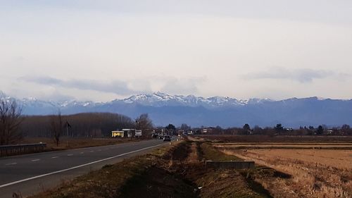 Road leading towards mountains against sky