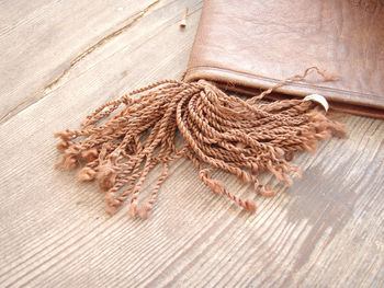 High angle view of rope and leather on hardwood floor