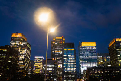 Low angle view of illuminated cityscape against sky