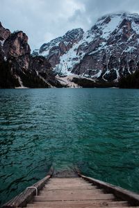 Scenic view of lake by snowcapped mountains against sky