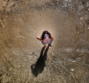 Aerial portrait of woman standing on beach