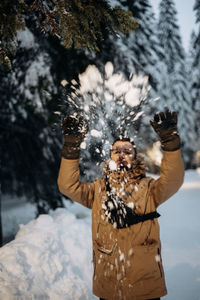 Close-up of woman standing on snow covered tree