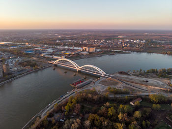 High angle view of bridge over river in city against sky during sunset