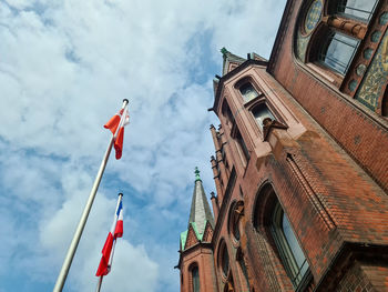 Low angle view of flags on building against sky