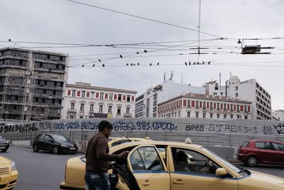 Man and woman on street in city against sky