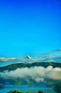 Aerial view of sea and mountains against clear sky