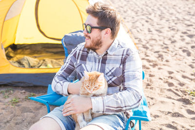 Man wearing sunglasses sitting on beach