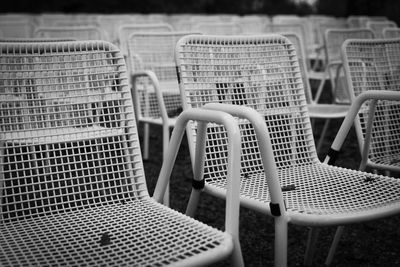 Rows of white metal garden chairs in front of an outdoor stage. series, 4of6