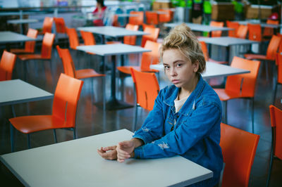 Portrait of woman sitting on chair in supermarket