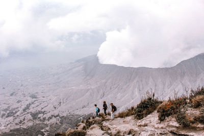 People on mountain range against sky