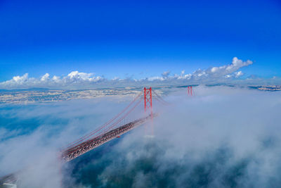 Aerial view of bridge over water against blue sky. 25th april bridge, lisbon, portugal 