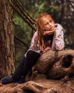 Portrait of a teenage girl sitting on tree