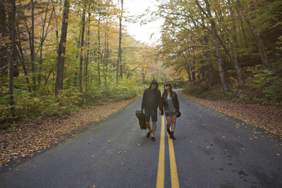 Young couple walking hand in hand down a road