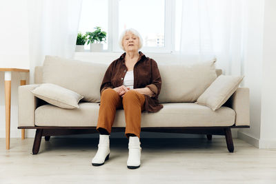 Young woman sitting on sofa at home