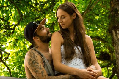 Couple sitting against trees