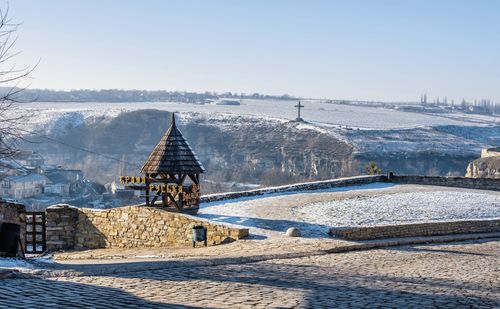 Built structure on snow covered land against sky
