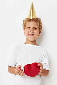 Portrait of young woman holding gift against white background