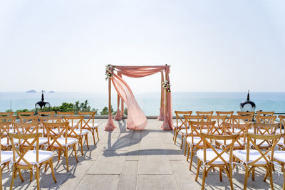 Chair at beach against clear sky